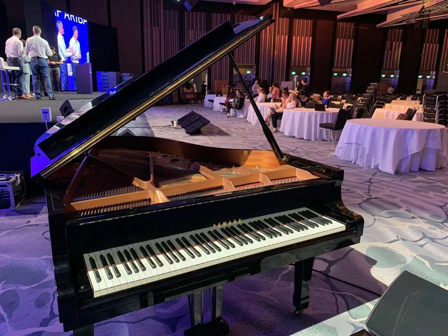 A grand piano set up in a ballroom before an event