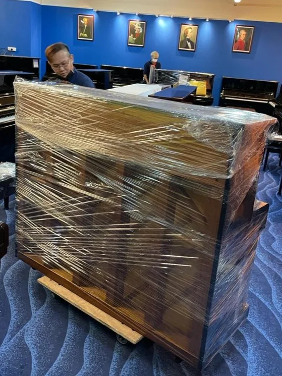 A piano crated on a pallet inside a venue