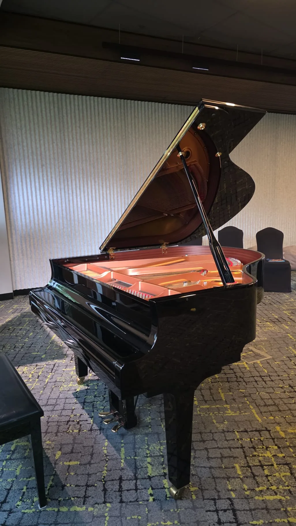 A grand piano with the lid raised in a function room