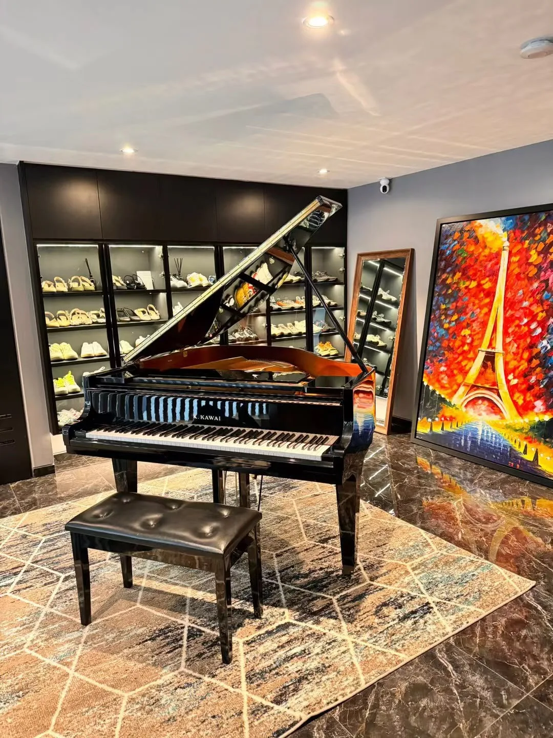 A grand piano in a private room with a painting on the wall