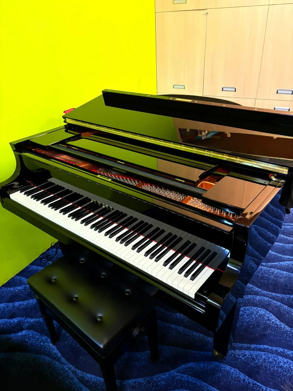 A Yamaha grand piano with the lid open in the viewing gallery
