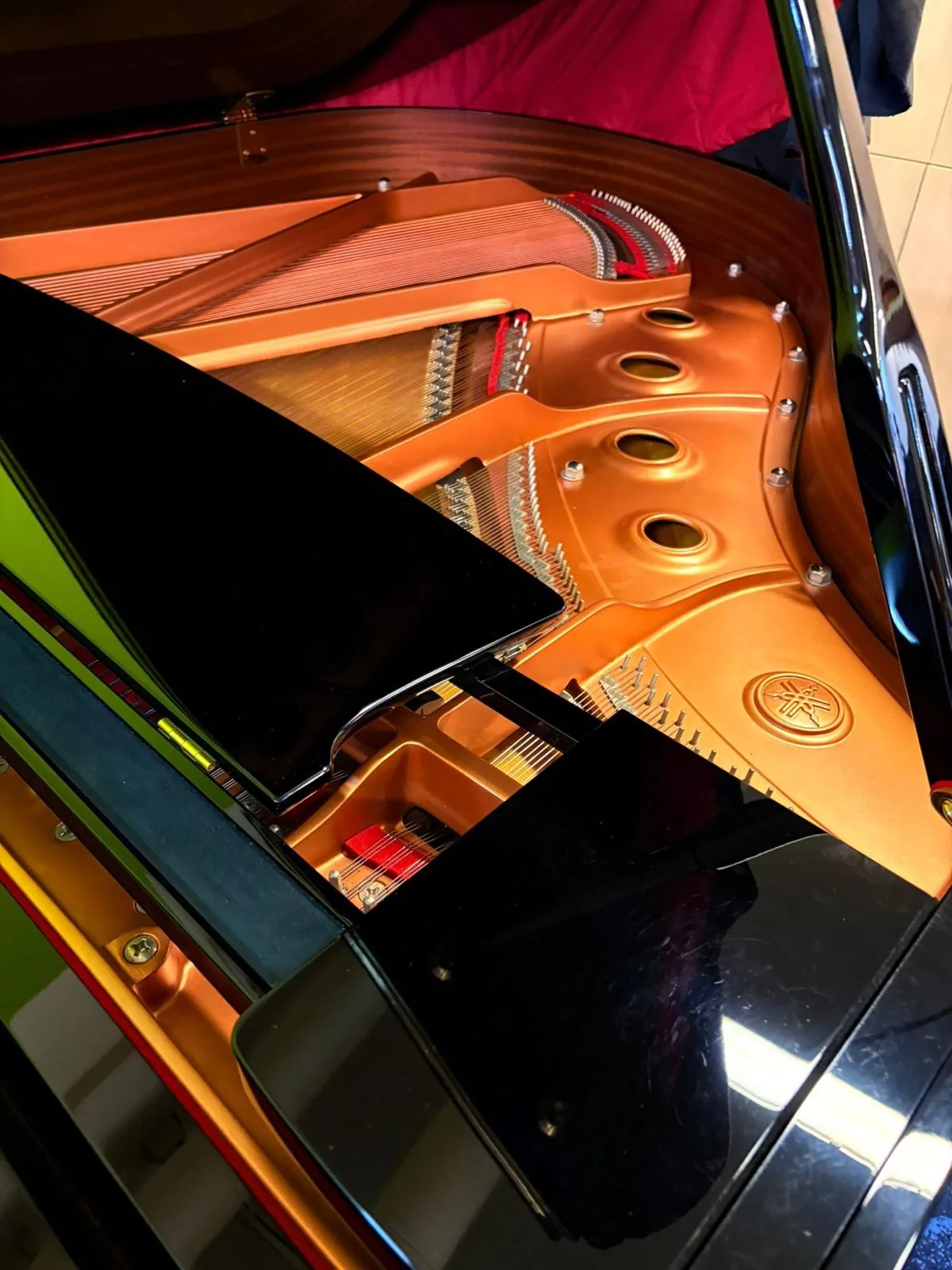 The Yamaha emblem on the plate inside a grand piano