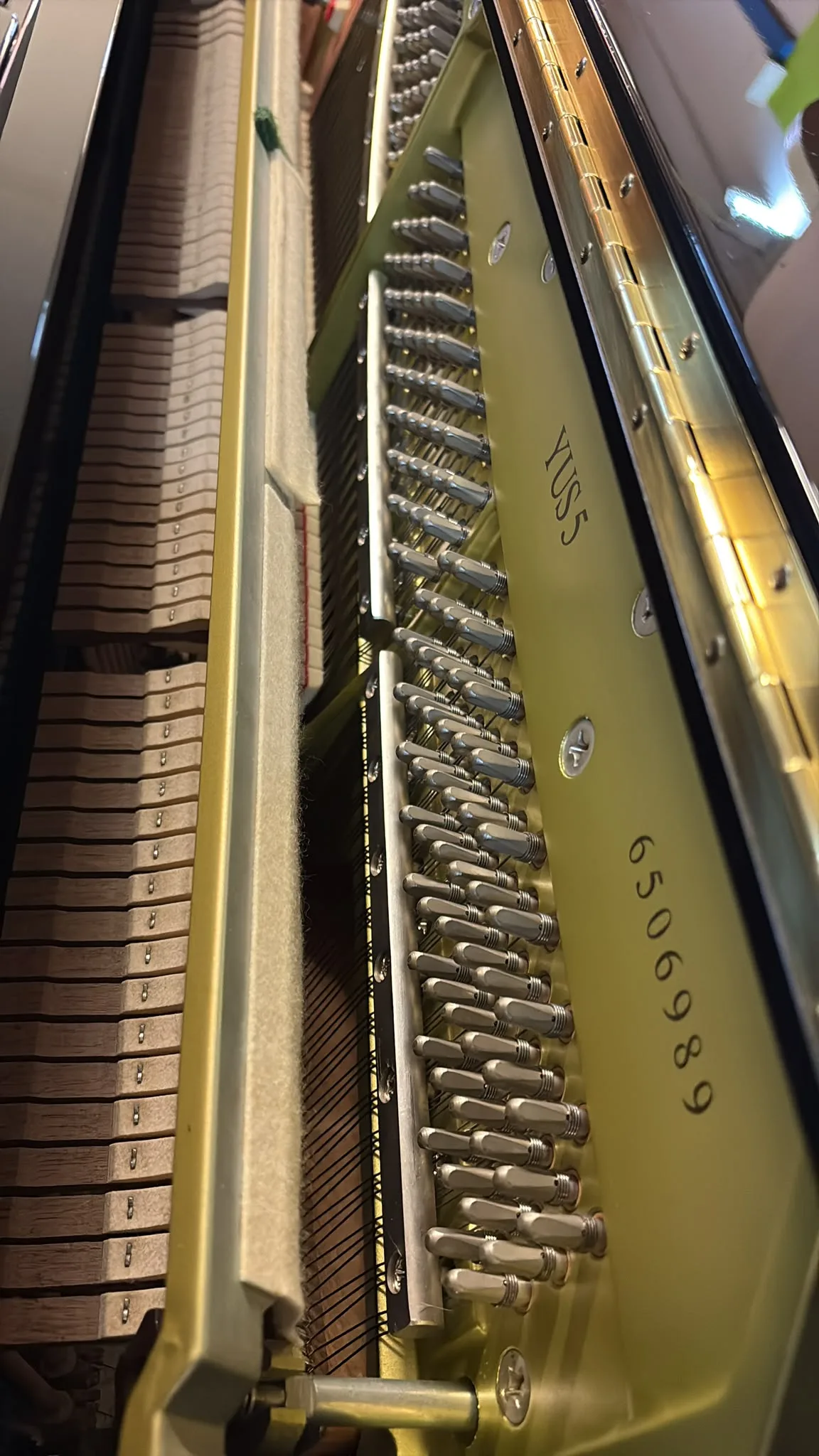 The tuning pins and hammers inside a Yamaha YUS5 upright piano