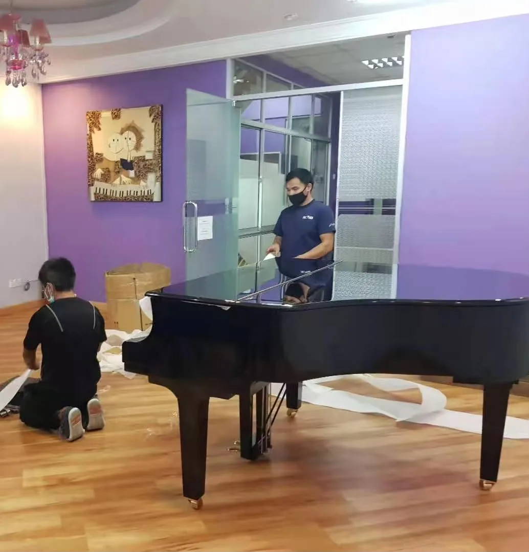 A grand piano unwrapped and placed in a studio room