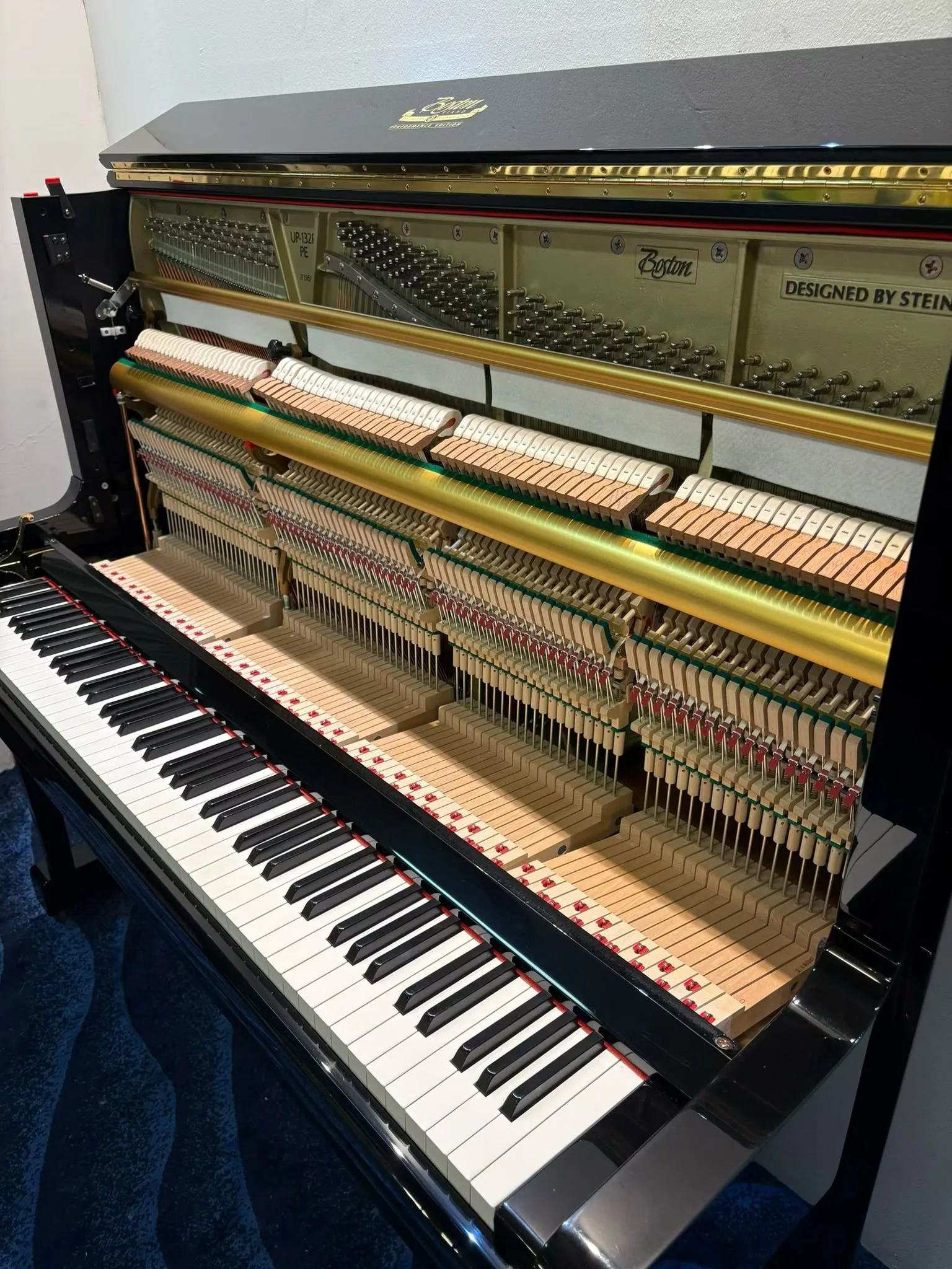 The hammers and strings of a Boston UP-132E upright piano seen from the treble end