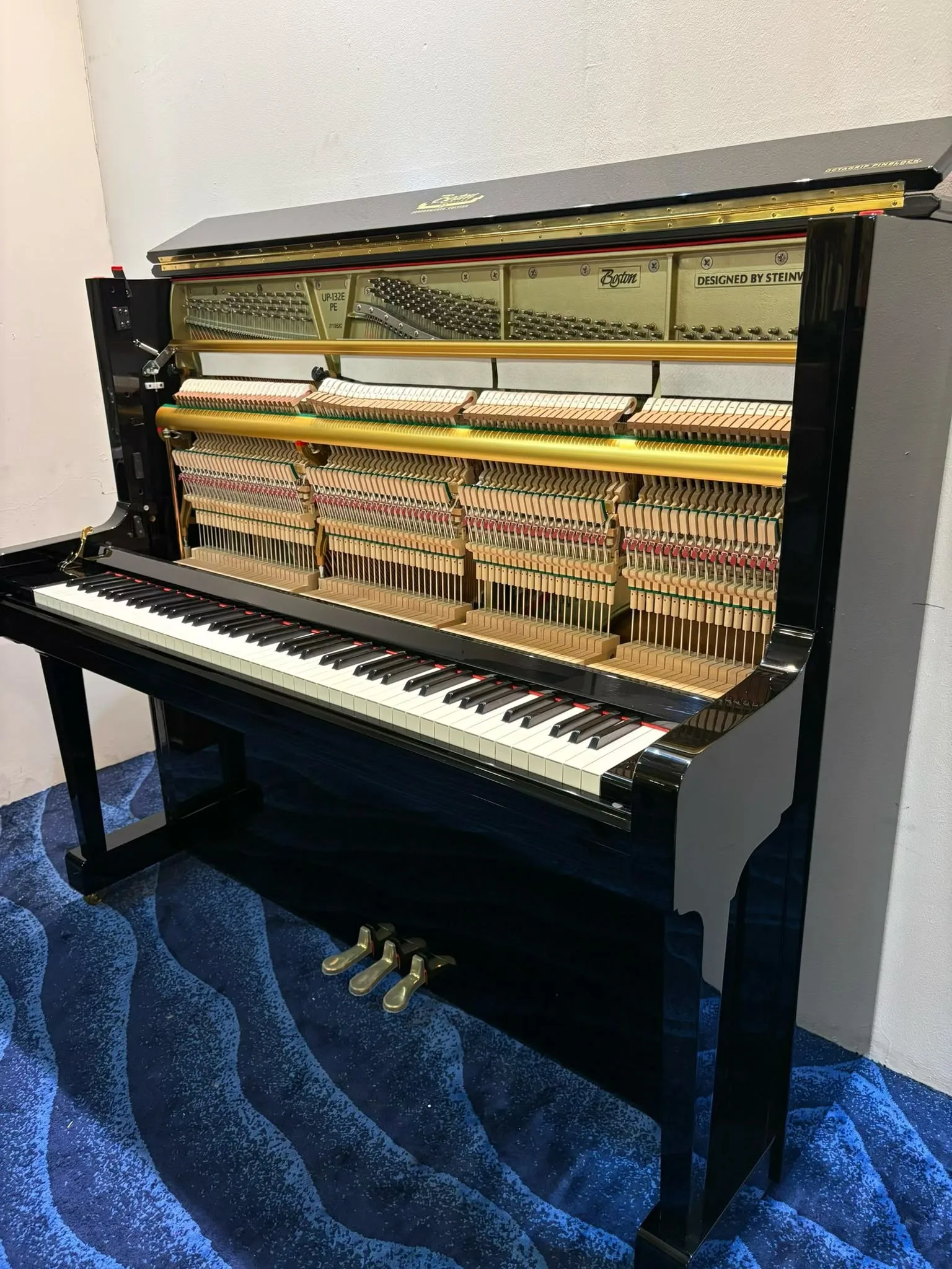 A Boston UP-132E upright piano with the top board off on the viewing gallery floor