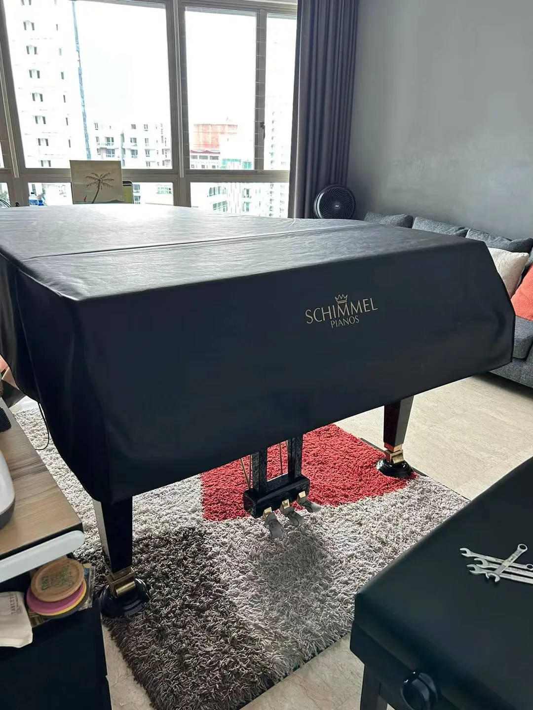 A Schimmel grand piano under its cover in a customer home