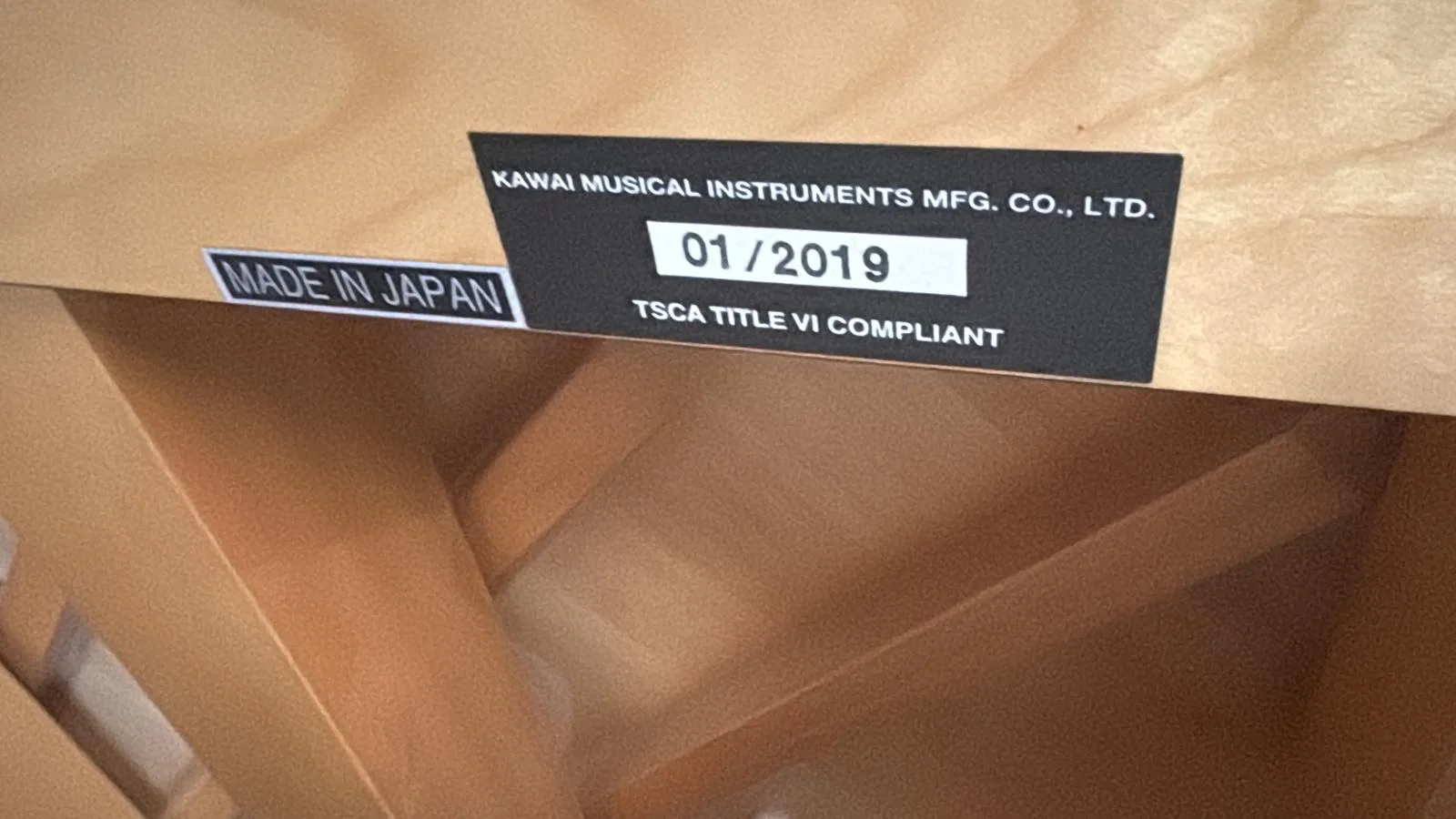 A Kawai factory label inside a piano case reading 01/2019 and made in Japan
