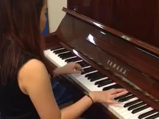 A Yamaha upright piano being played at home